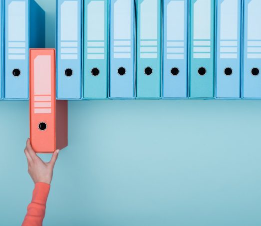 Office worker taking a folder in the archive